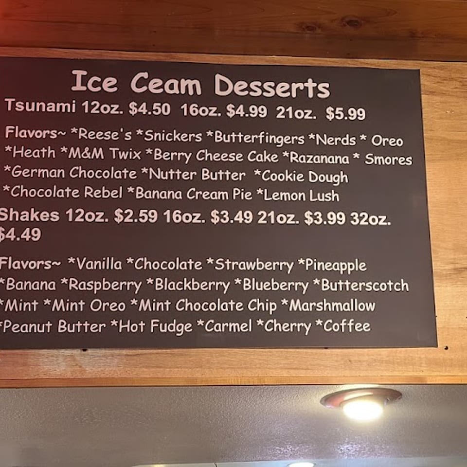 Ice cream and shake menu board with prices and many flavor options in a restaurant.